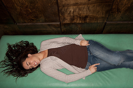 年轻女孩躺在绿床垫上图片