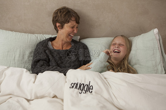 母亲和女儿在床上笑图片