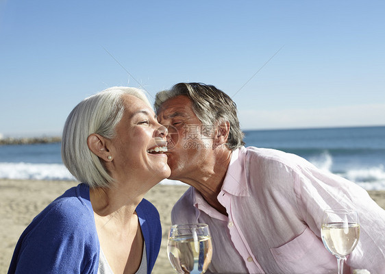 亲吻在妇女的脸颊上的老夫妻图片