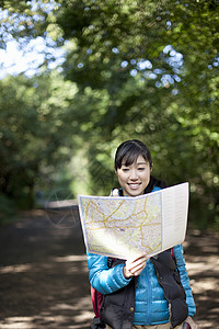 年轻女远足者看地图图片
