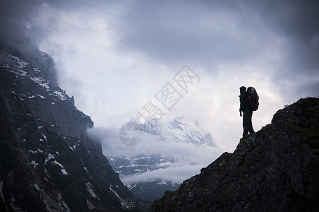 成功攀登山顶的背包客图片