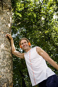 成年男性在树林中做跑步前拉伸图片