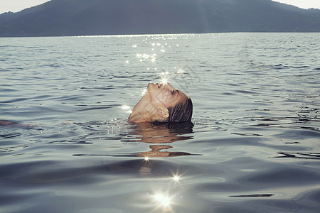 在湖里游泳的年轻女子图片