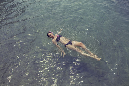 年轻女人漂浮在湖面上图片