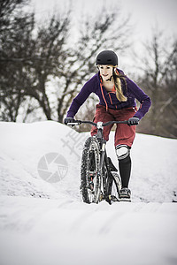 在雪中骑行的女子图片