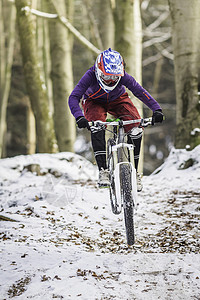 冬季森林中的年轻女子骑自行车图片