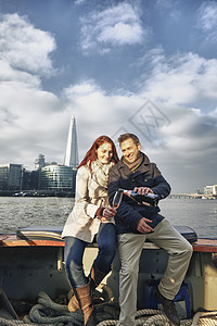 泰晤士河边分享粉红香槟的浪漫情侣图片