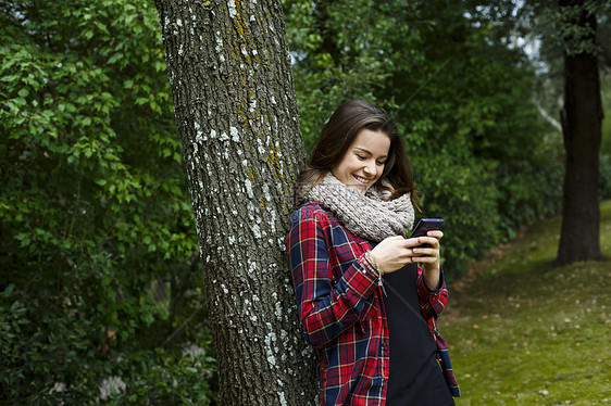 在森林中使用手机的少女图片