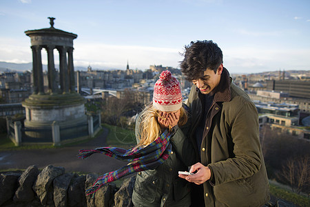 一对年轻夫妇在苏格兰首府爱丁堡市的卡尔顿山上拍照图片