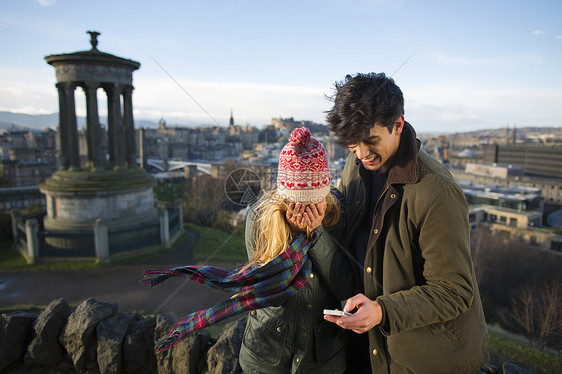 一对年轻夫妇在苏格兰首府爱丁堡市的卡尔顿山上拍照图片