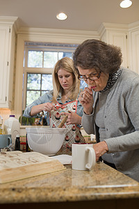 高级妇女和孙在厨房做烘烤图片