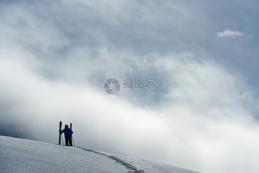 奥地利Obergurgl山上站立的中成年男子滑雪运动员图片