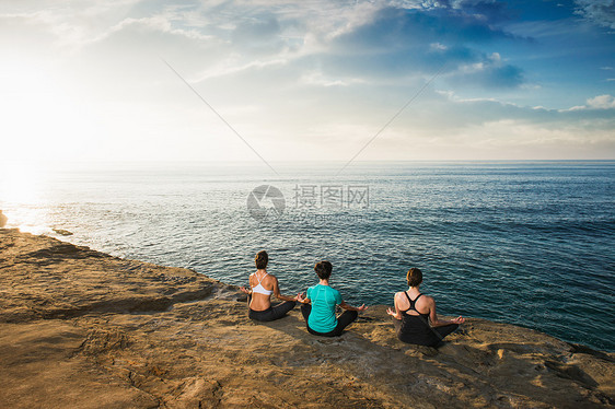 坐在悬崖顶上看着海和冥想的女人图片