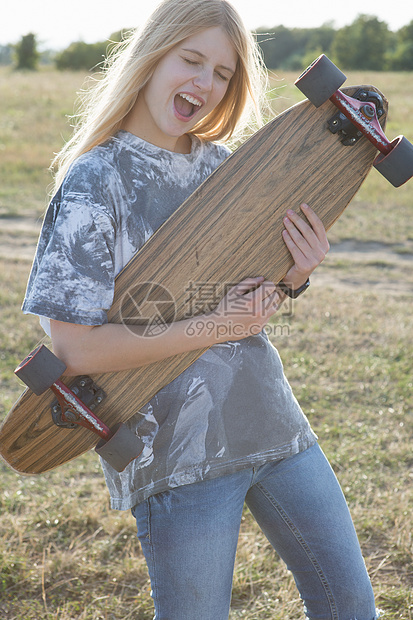 年轻女子用滑板弹空中吉他图片