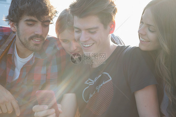 四个朋友在看智能手机图片