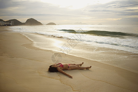 巴西里约热内卢日落时分在科帕卡巴纳海滩上晒日光浴的年轻女性图片