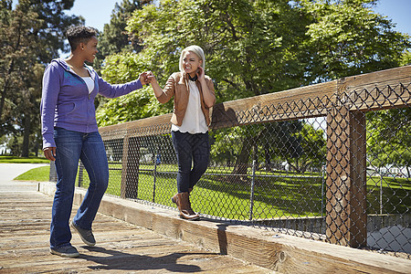 在公园桥上漫步的年轻女性图片