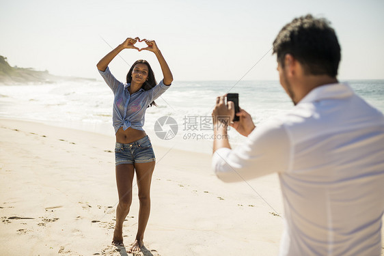 情侣在巴西里约热内卢的海滩上拍照图片