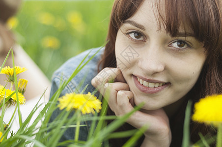 年轻女性躺在草地上与黄色花朵的合照图片