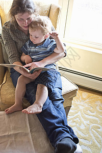 中年母亲在家给小儿子读故事书图片