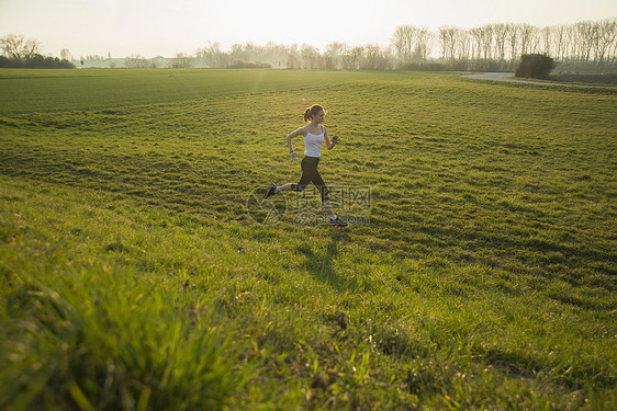 年轻女在田中跑步图片