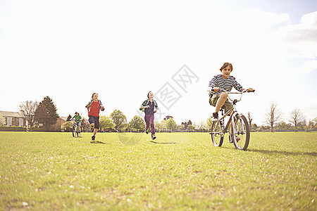 一群在户外奔跑骑自行车的男孩图片