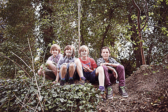 4个男孩坐在森林里图片