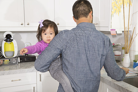 在厨房中怀着女儿的成人男子图片