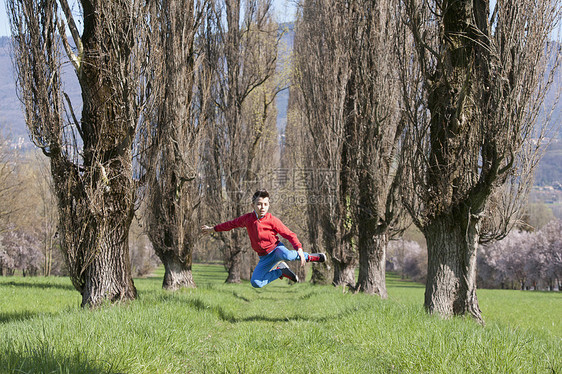 男孩在树林中跳跃图片