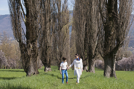 1男孩和母亲沿树林漫步图片
