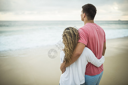 巴西里约热内卢海滩上拥抱的年轻夫妇图片