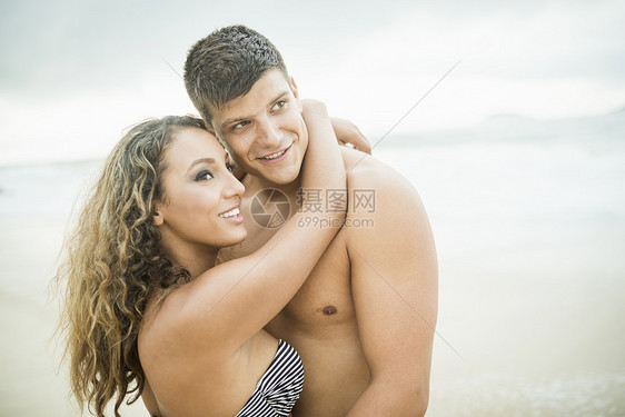 海滩上拥抱的年轻夫妇图片