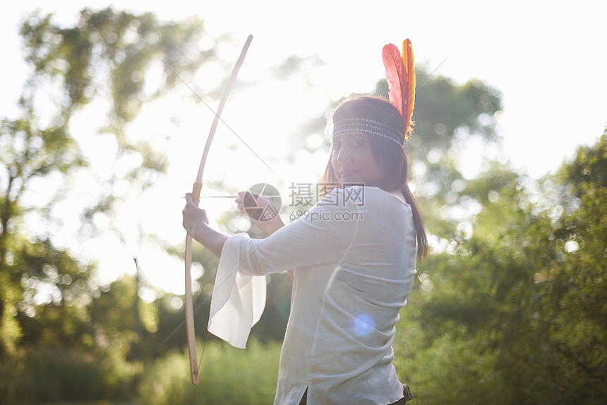 头上绑着羽毛的女子正在拉弓图片