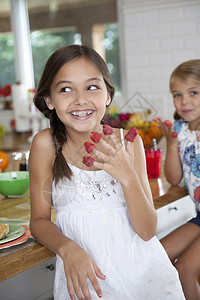 在厨房里手指上沾着草莓的搞怪姐妹图片