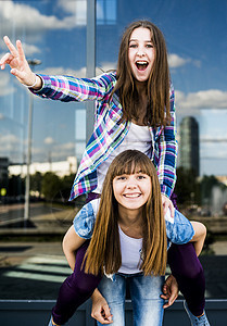 在办公楼外墙玻璃前两名年轻妇女摆姿势图片