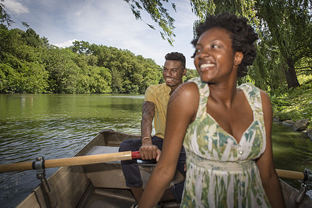 在公园湖上划船的年轻夫妇图片