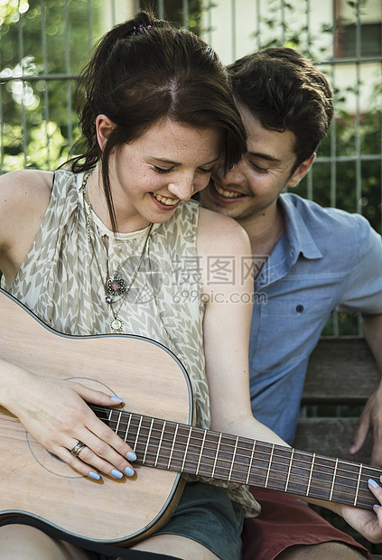 年轻夫妇在公园里弹吉他图片