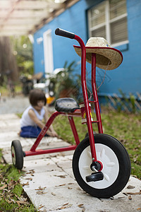 在花园路上女孩面前的三轮车图片