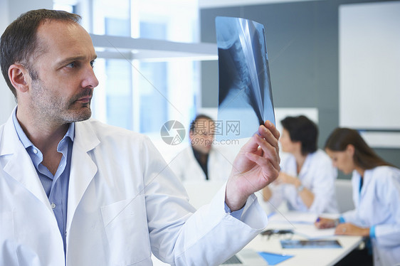 男医生在看X光同事后面讨论图片