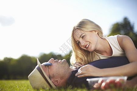 在公园里躺在草坪上聊天的夫妇图片