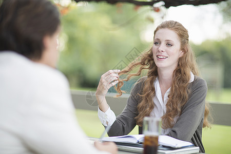 在花园举行非正式会议的商人和女同事 图片