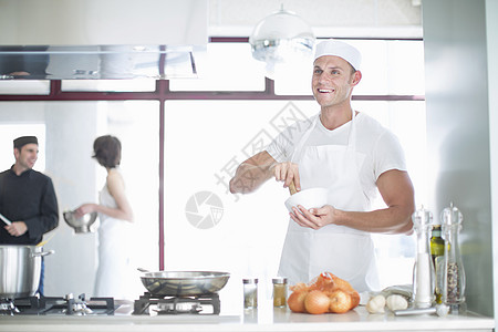 商业厨房中微笑的男厨师图片