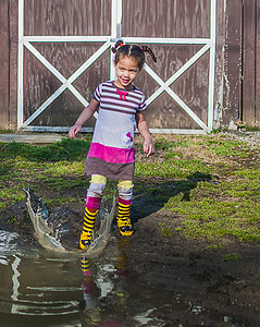 女孩在花园水坑上玩耍图片