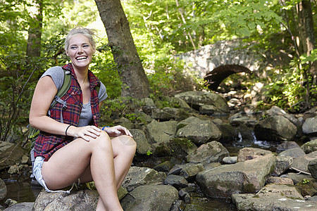 坐在湖边岩石上的女人图片