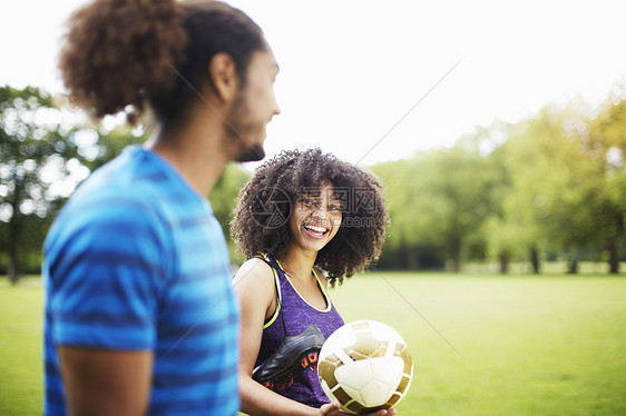 在公园聊天的年轻足球夫妇图片