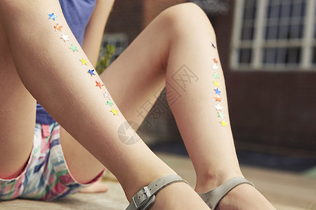 女孩腿的特写镜头一排星星贴纸图片