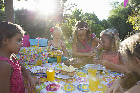 女孩和朋友一起切生日蛋糕图片