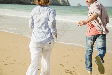 海滩上奔跑的成熟夫妇图片