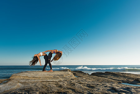 海滩上做瑜伽的情侣的图片
