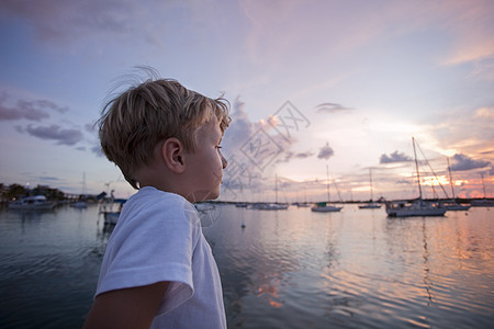 男孩在帆船上仰望着日落图片